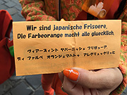 Überraschender Besuch von japanischen Frisören bei Heinzelmann: die beatunten die Dirndl, wir deren oranges Outfit